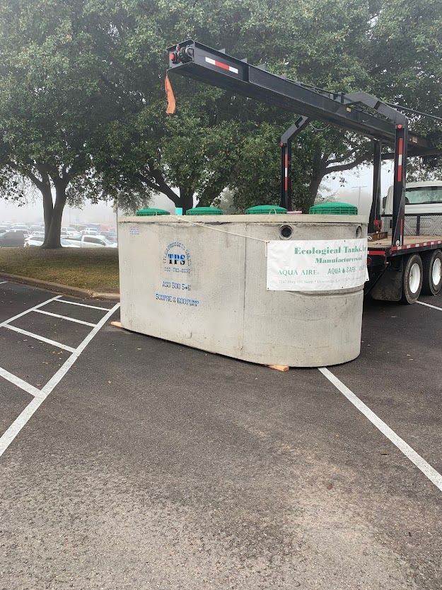 A large concrete block is being lifted by a crane on the back of a truck.