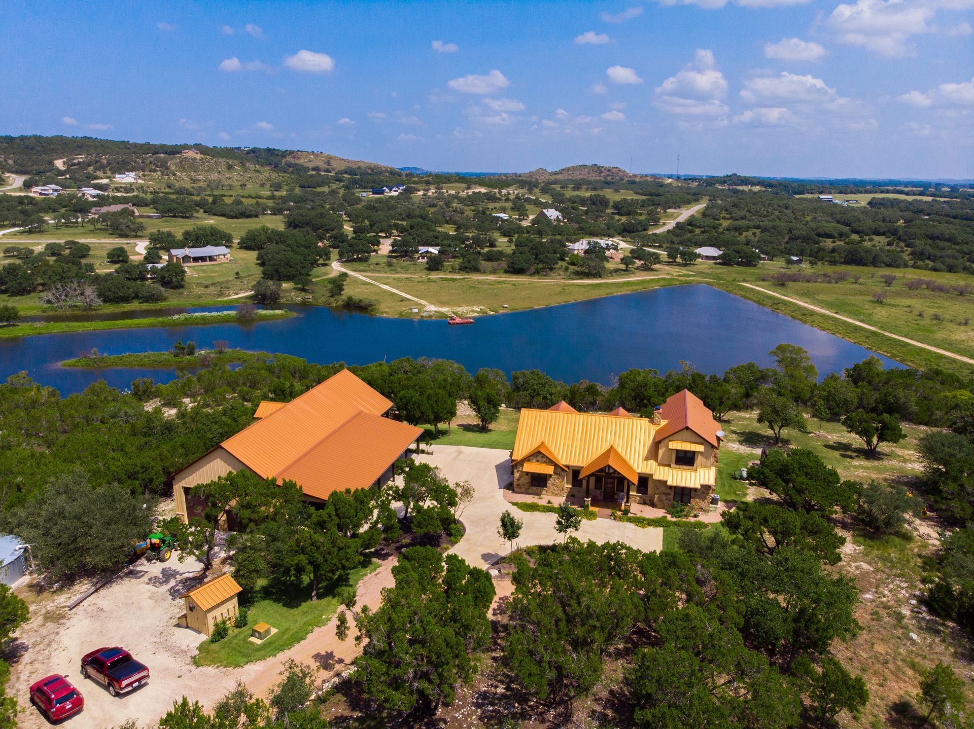 An aerial view of a large house surrounded by trees and a lake in Texas.
