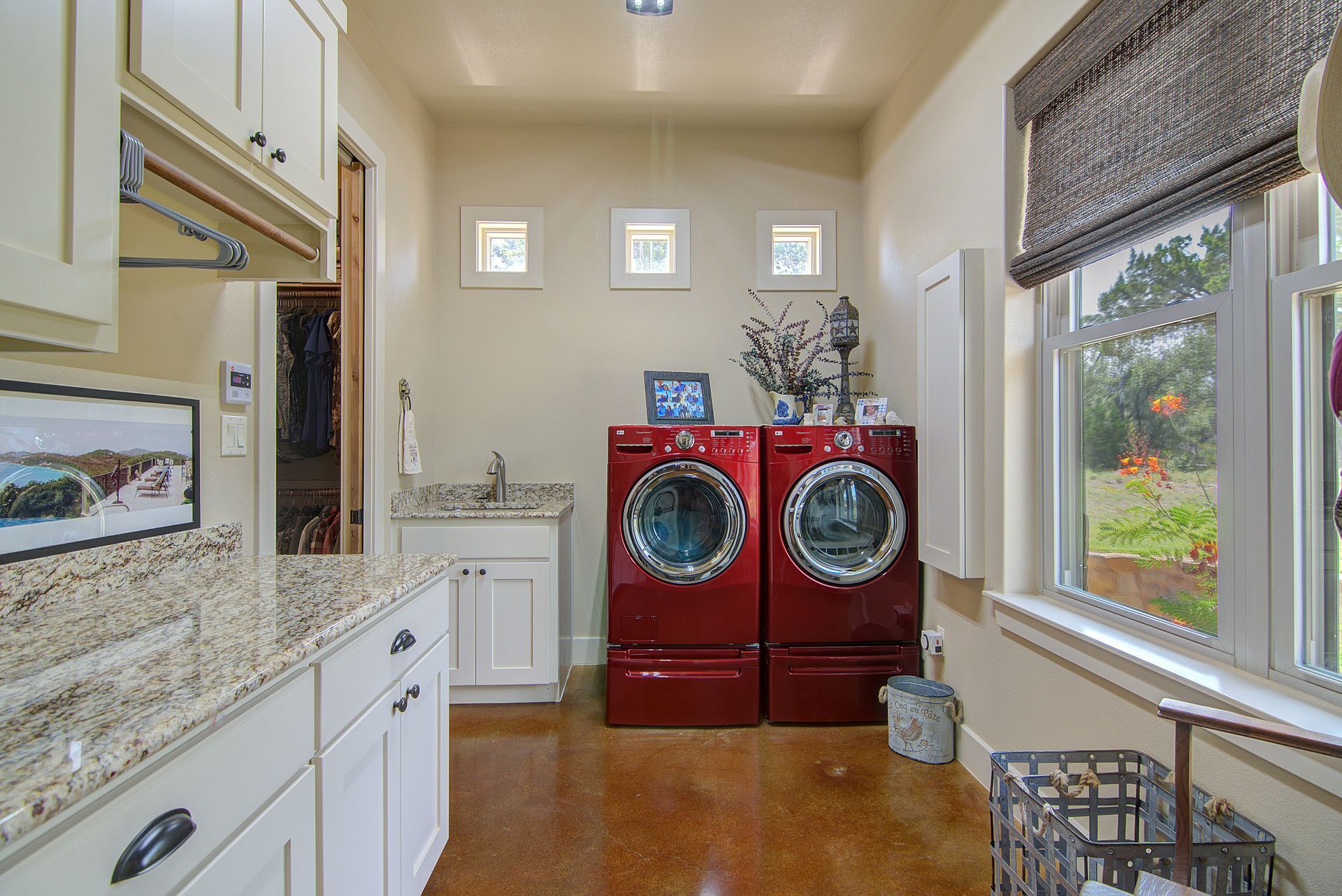 A laundry room with two red washers and dryers.