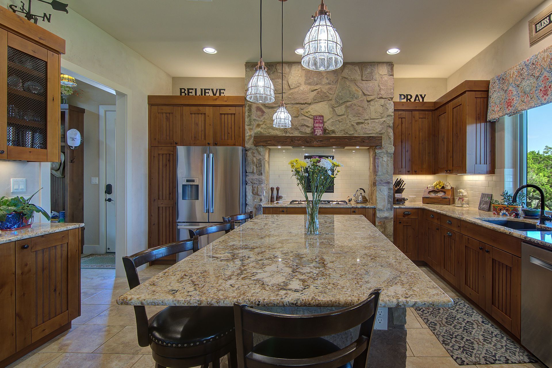 A kitchen with a large island and a vase of flowers on it.
