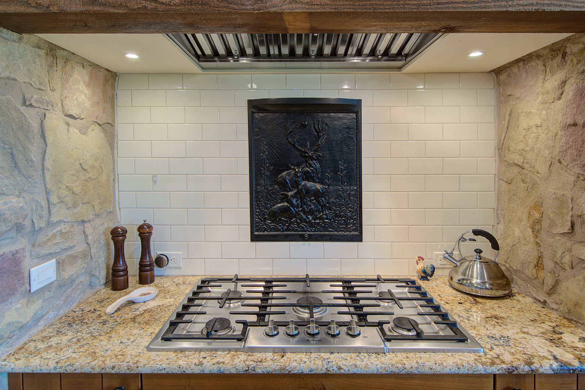 A stove top oven is sitting on top of a granite counter in a kitchen.