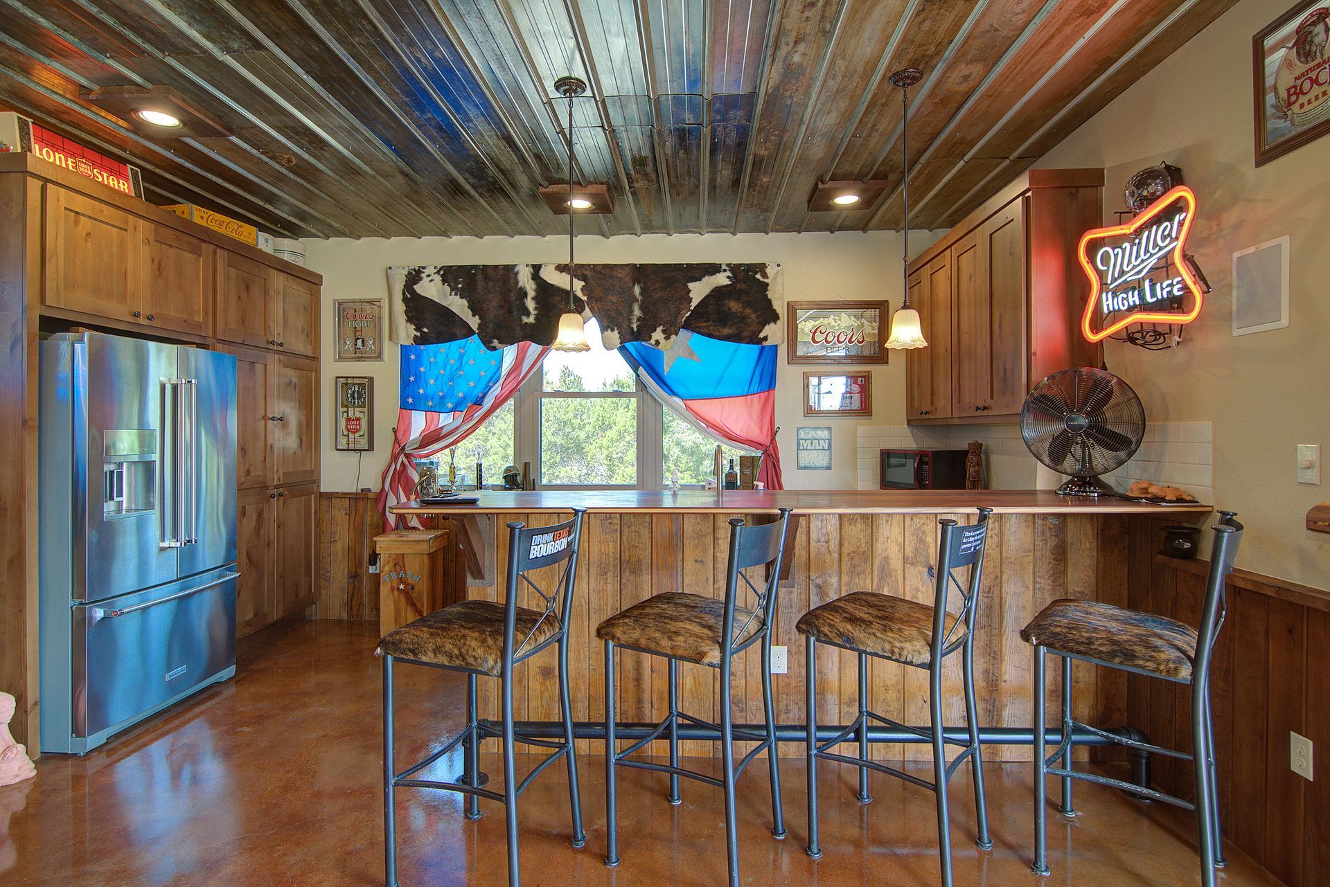 A kitchen with a bar and a budweiser neon sign