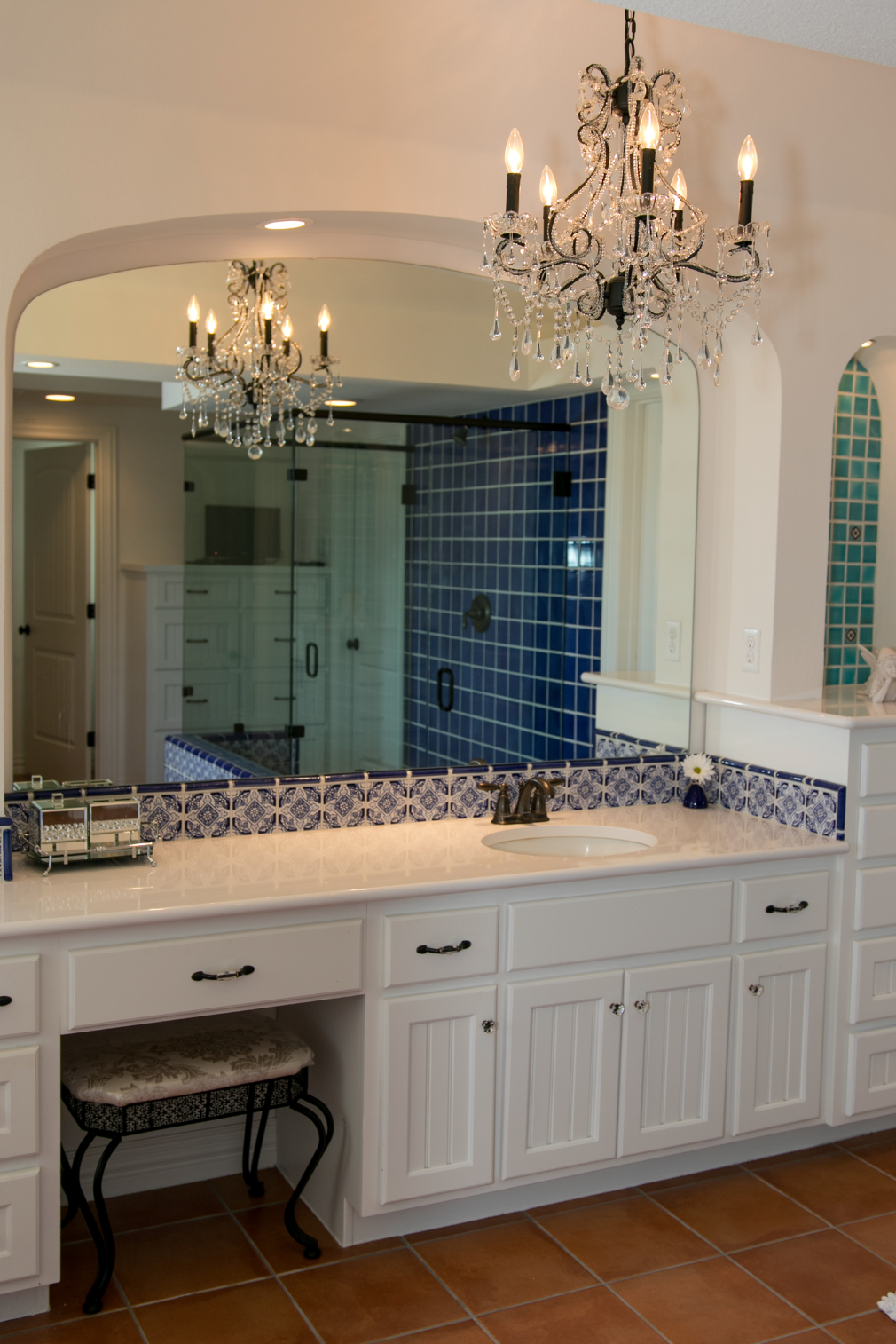 A bathroom with a large mirror and a chandelier