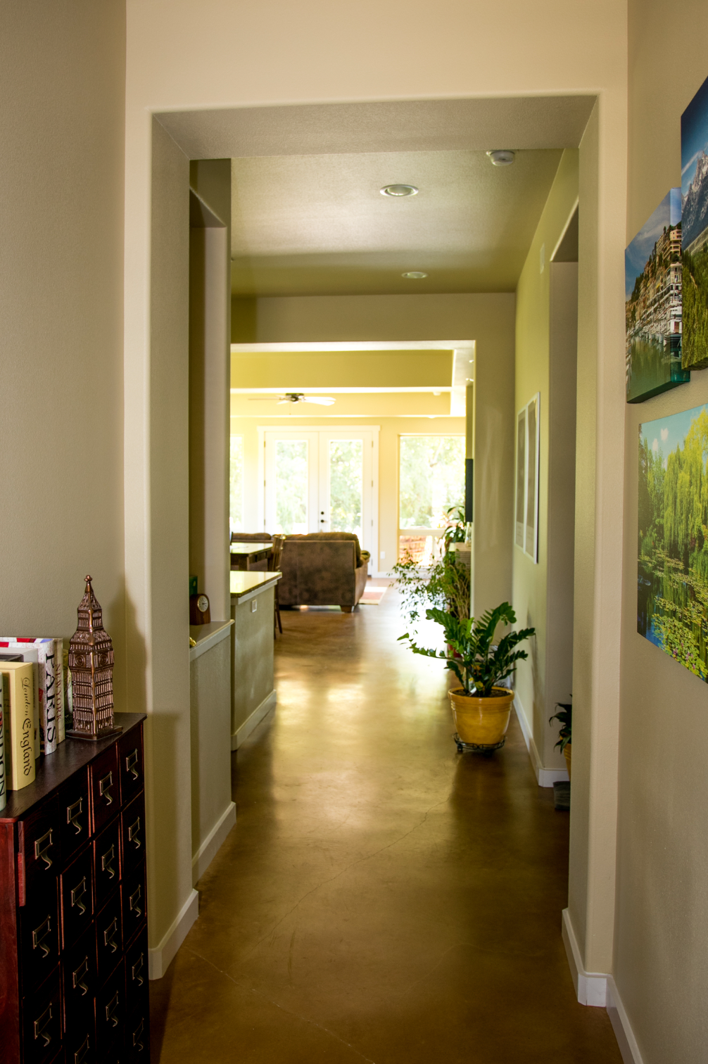 A hallway in a house leading to a living room.