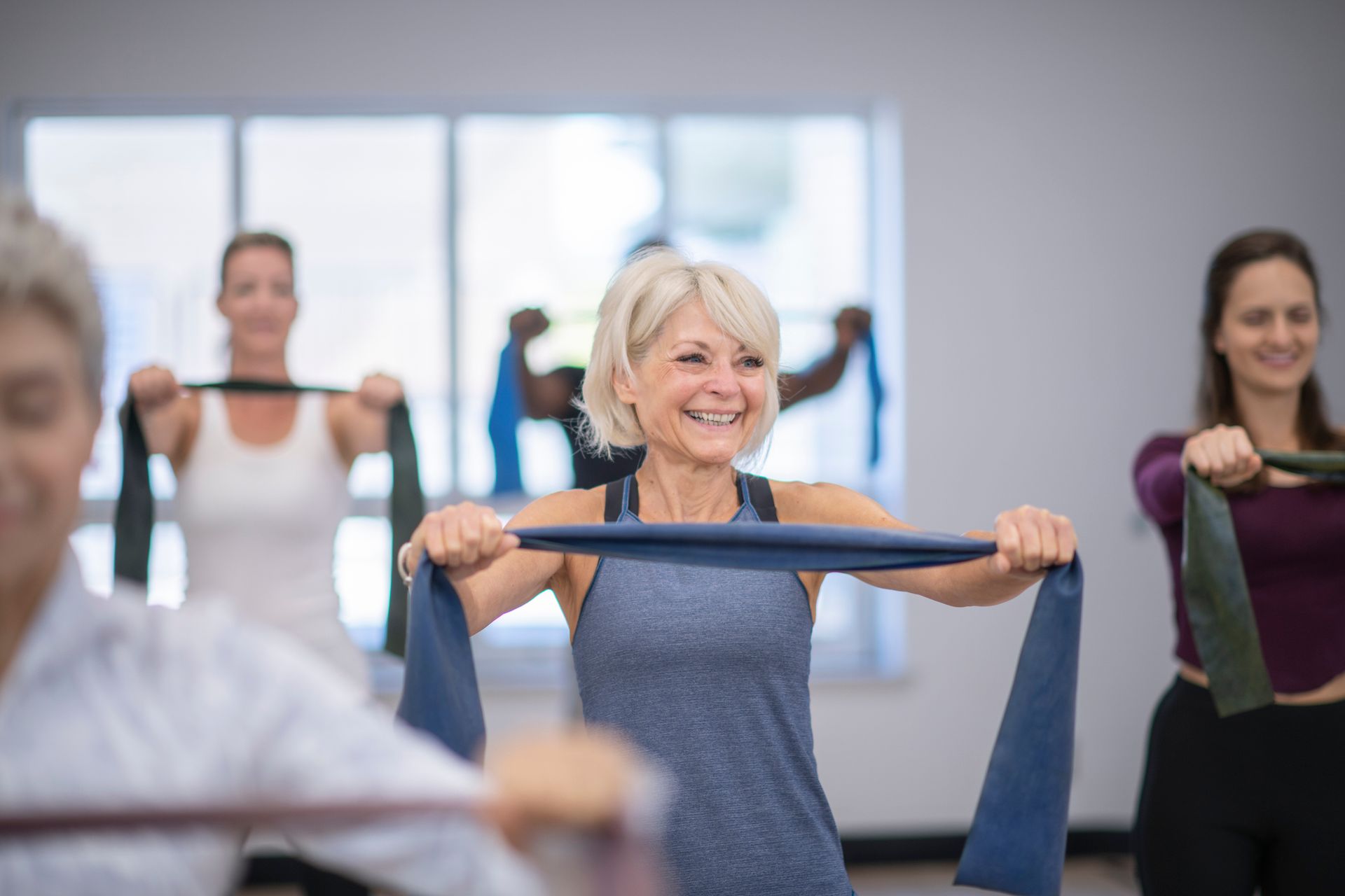 Un gruppo di persone sta facendo esercizi con le fasce di resistenza in una palestra.
