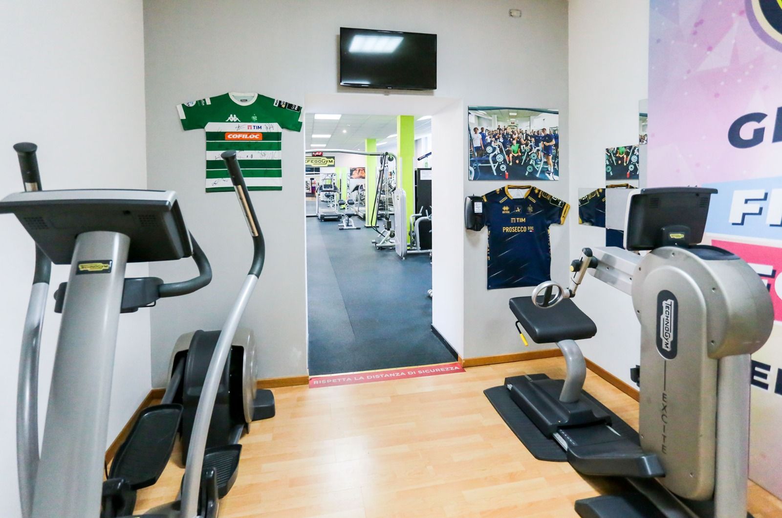 Una palestra con un tapis roulant e un'ellittica