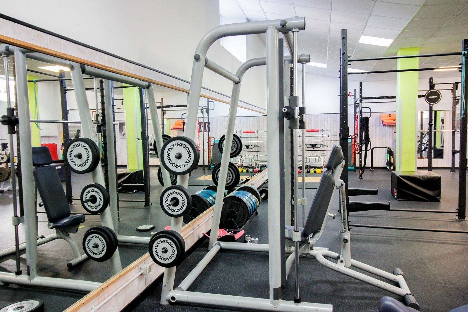 Una palestra piena di attrezzi ginnici e specchi.