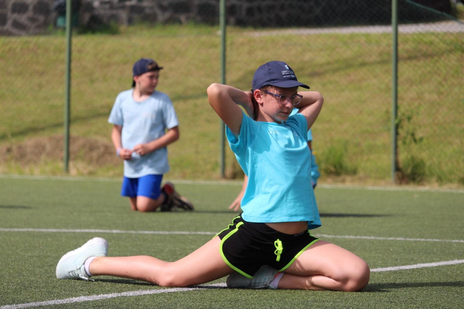 Una ragazza è seduta sull'erba e allunga le gambe.