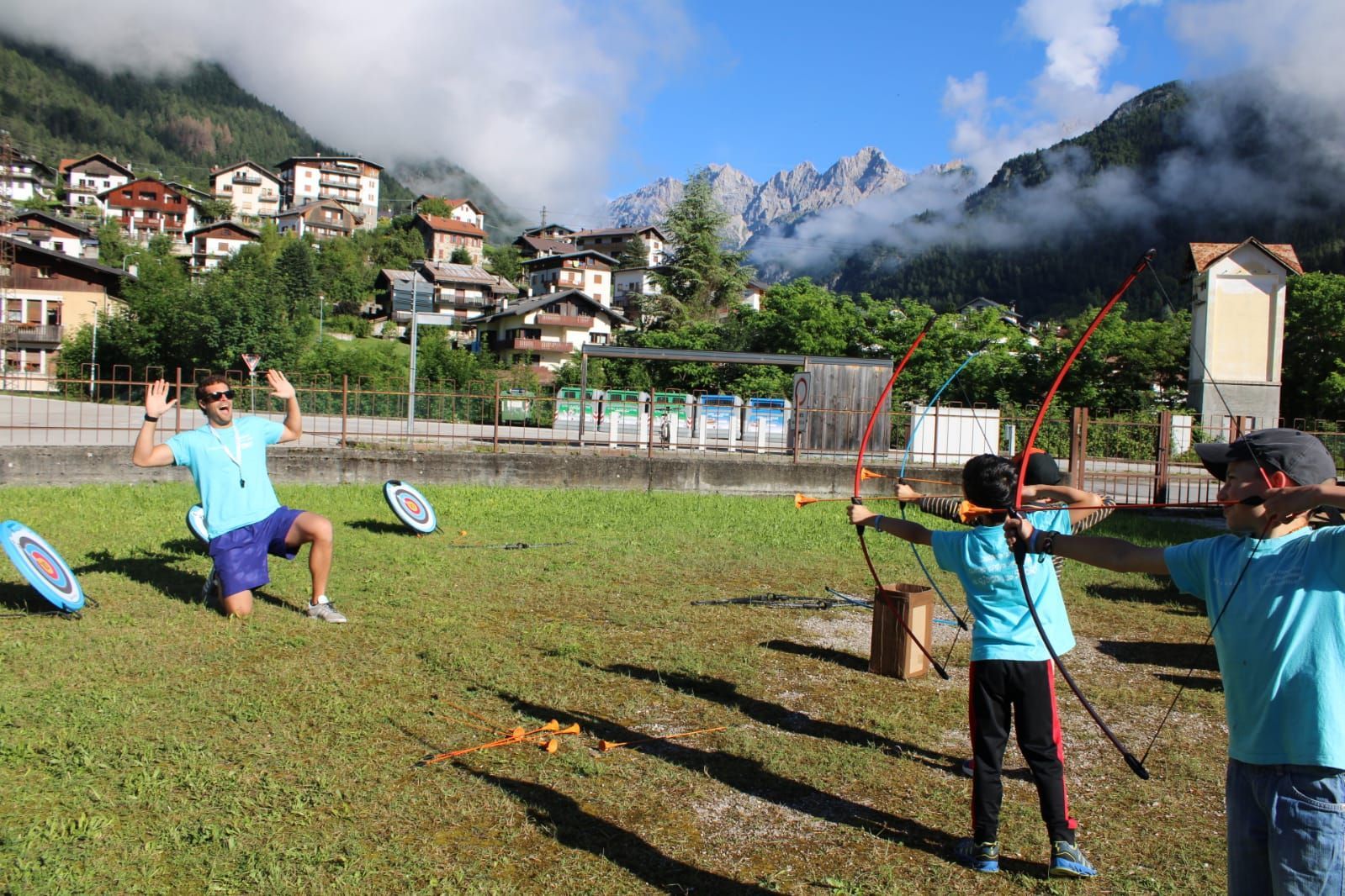 Un uomo e un bambino si esercitano nel tiro con l'arco in un campo.