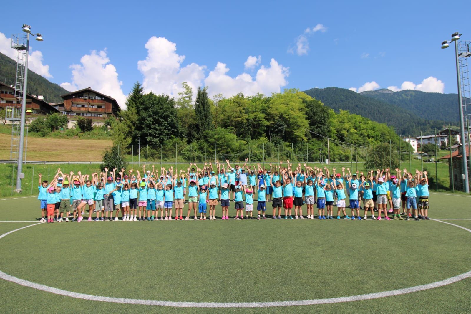 Un folto gruppo di persone posa per una foto su un campo da calcio.