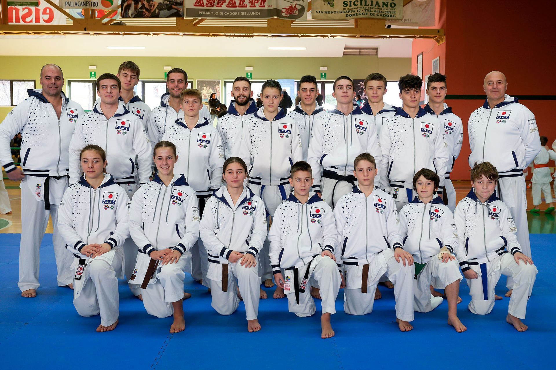 Un gruppo di persone posa per una foto in una palestra.