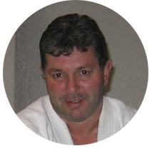 Un uomo in tunica bianca sorride in cerchio