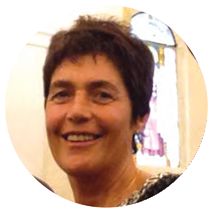 Una donna con i capelli corti sorride in cerchio.