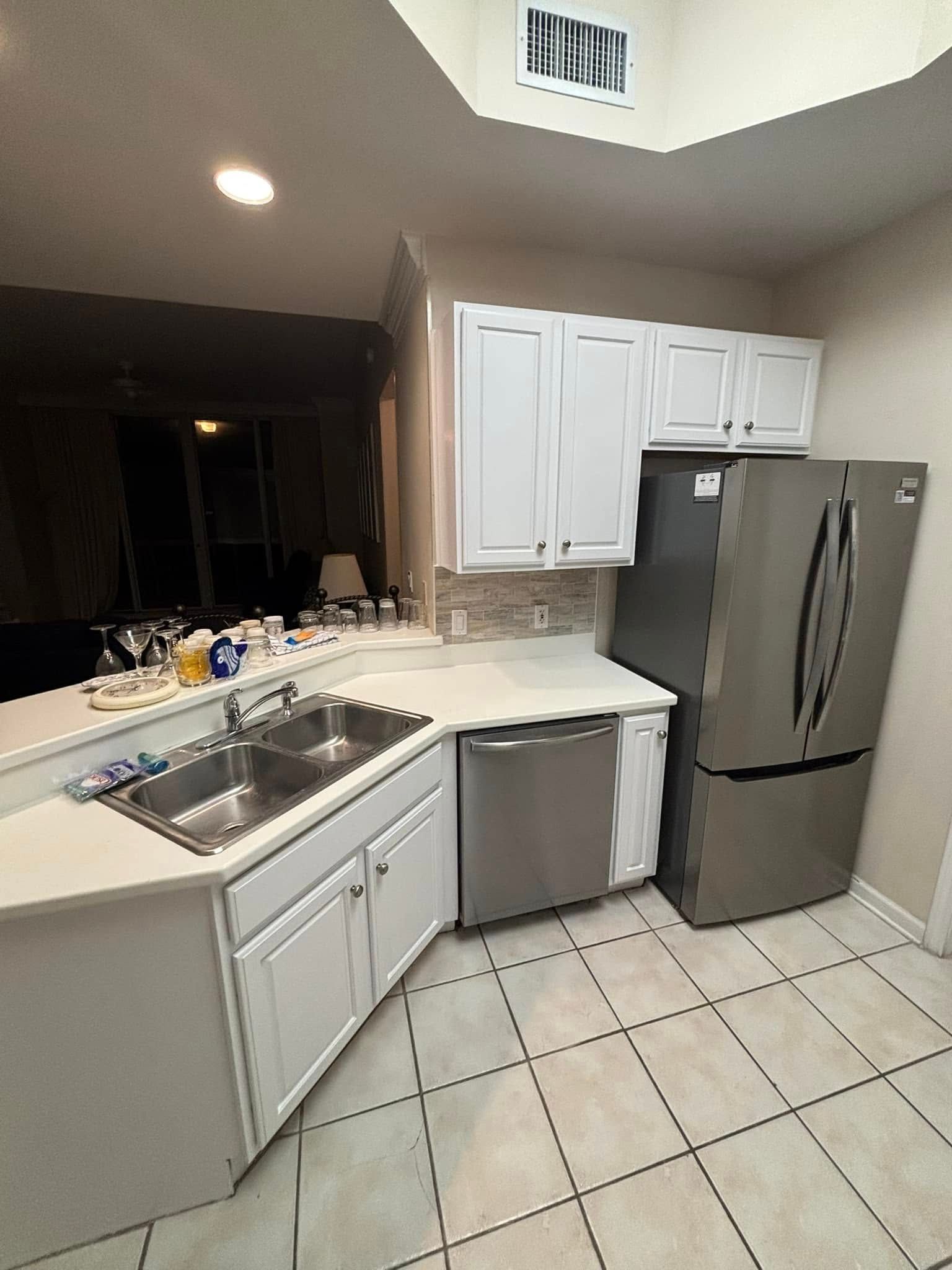 Kitchen with white cabinets, stainless steel appliances, and light-colored countertops.