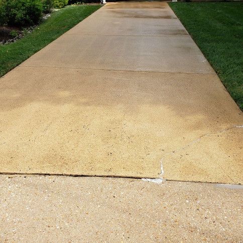 Concrete driveway with grass on either side.