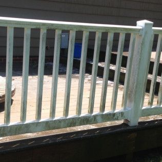 White deck railing with green algae buildup.
