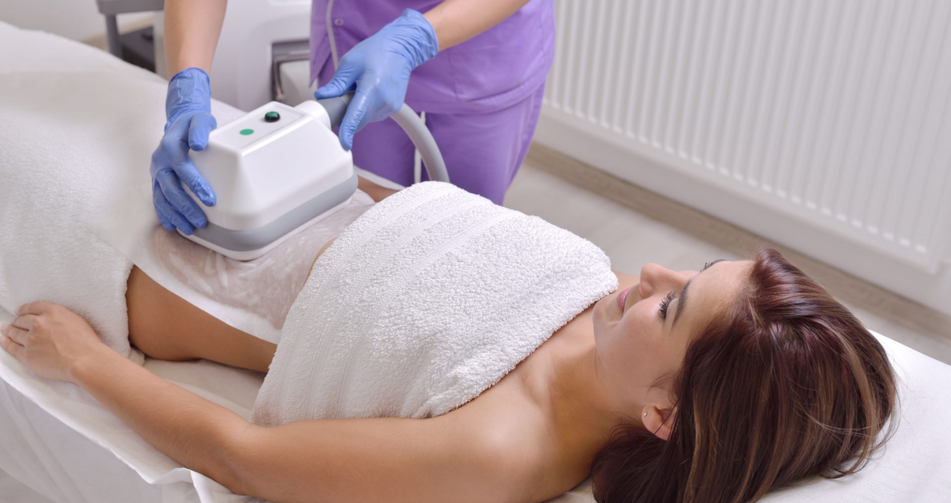 Eine Frau liegt auf einem Bett und bekommt eine Bauchbehandlung.