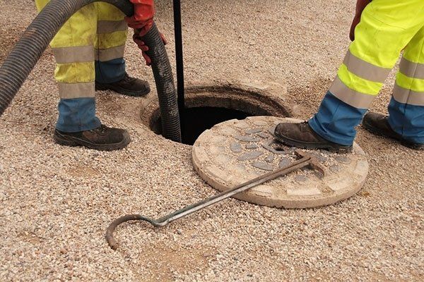 Due operai mentre disostruiscono un tombino