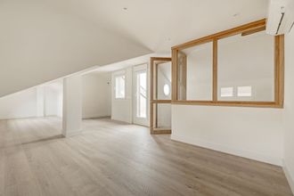 a large empty room with hardwood floors and a window .