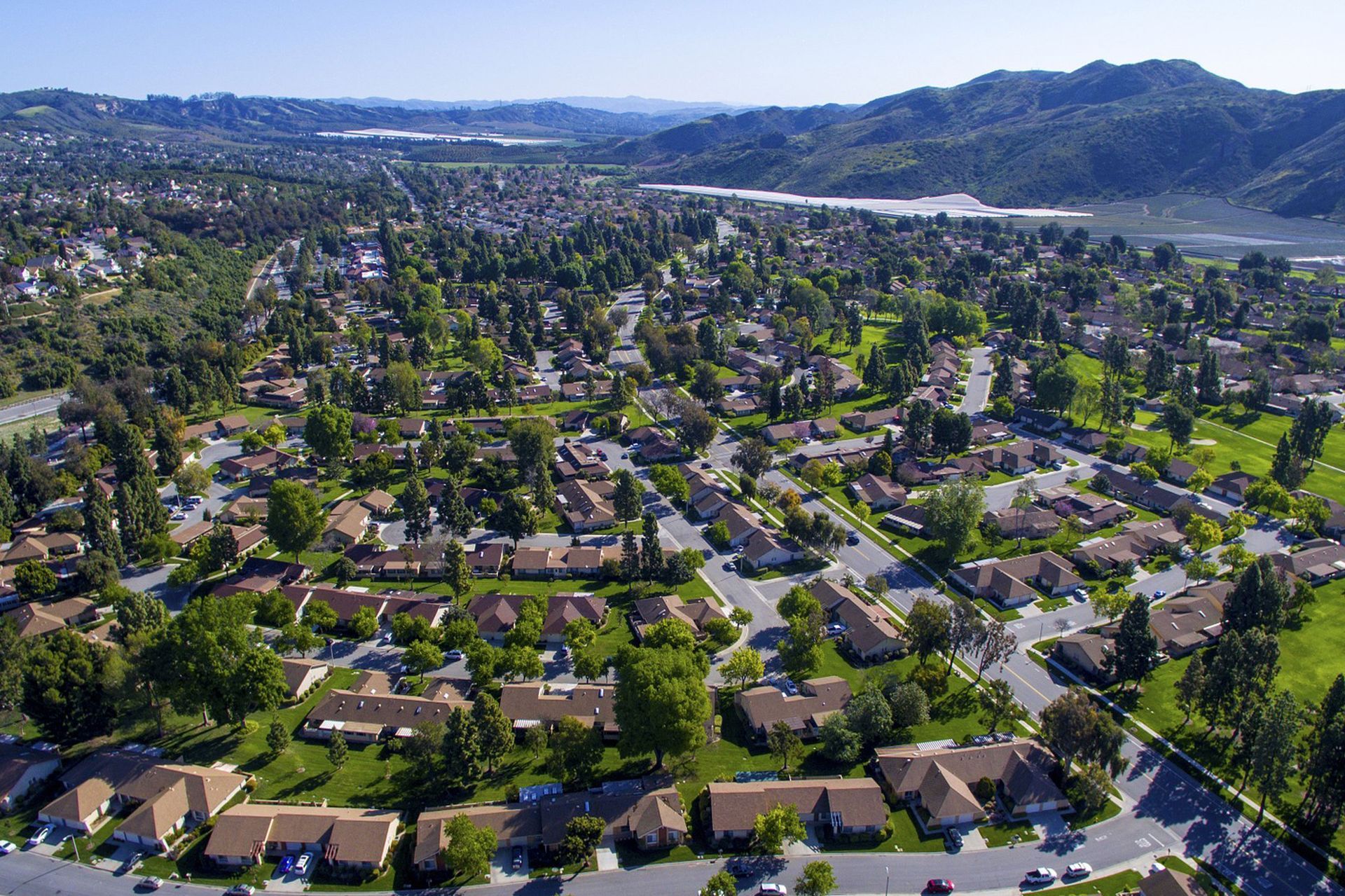 An aerial view of a residential area with mountains in the background