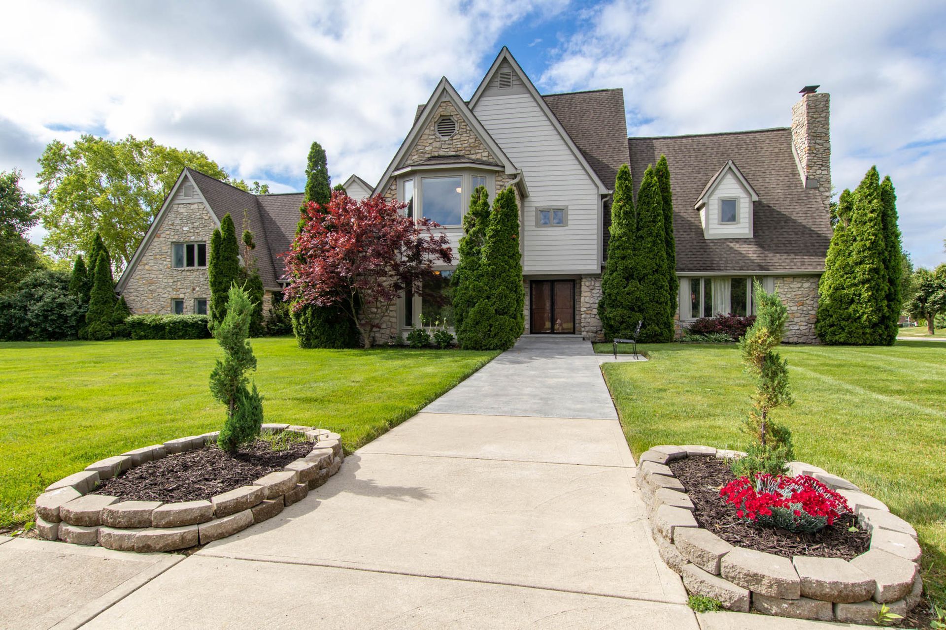 A large house with a lush green lawn is for sale