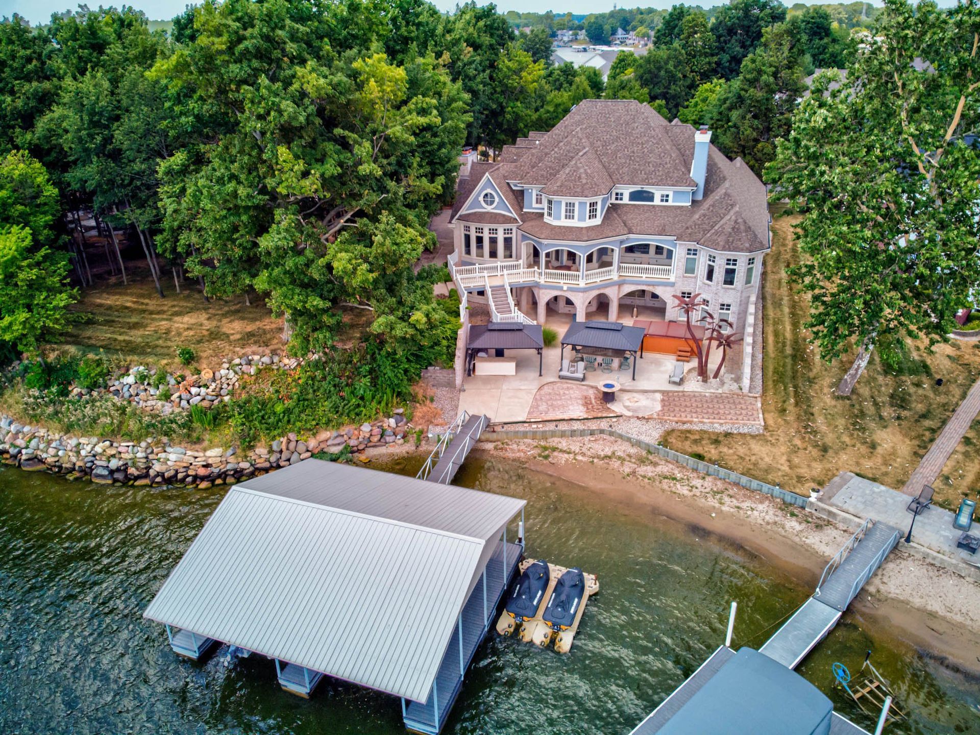 An aerial view of a large house sitting on top of a lake next to a dock .