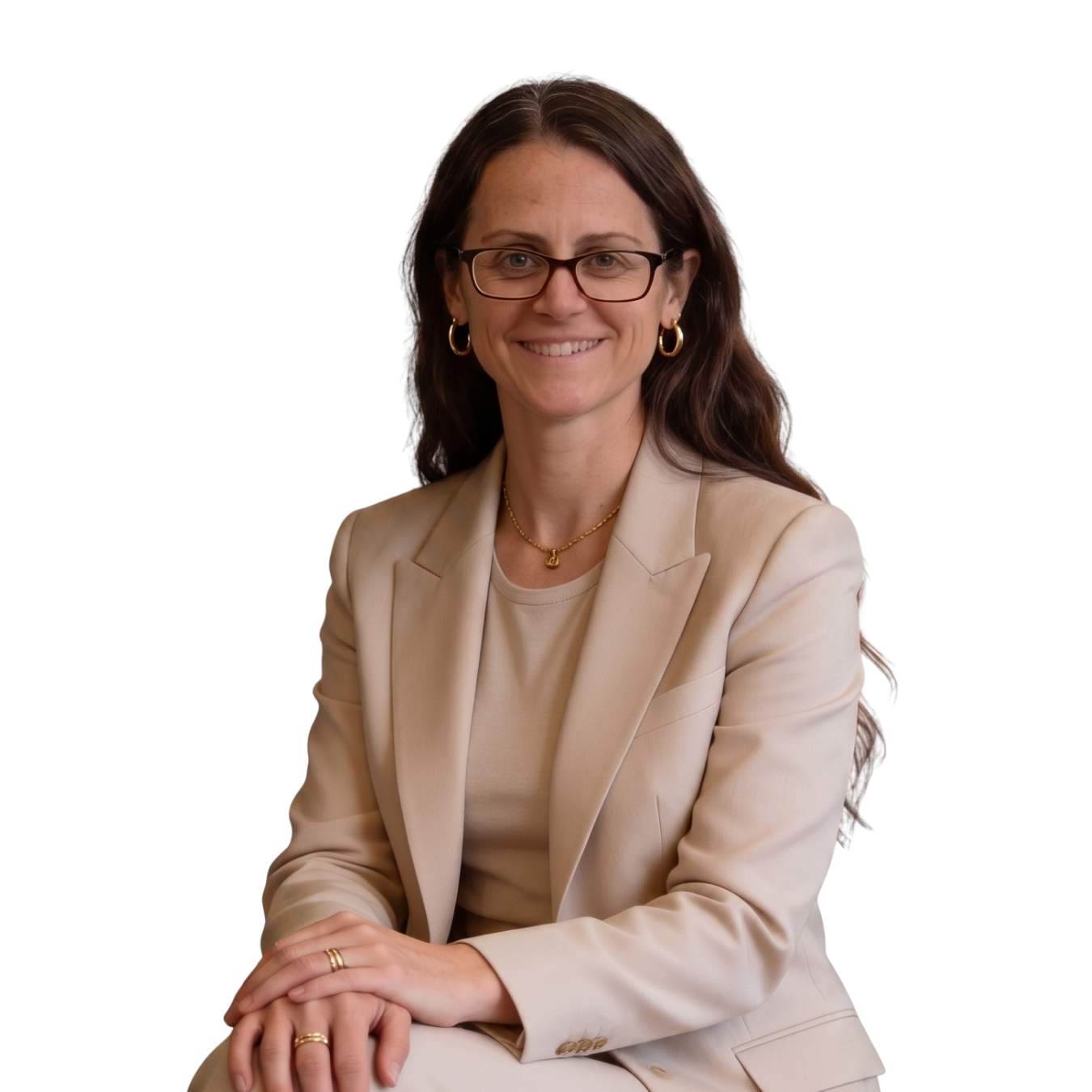 Woman in beige blazer seated and smiling against a white background.