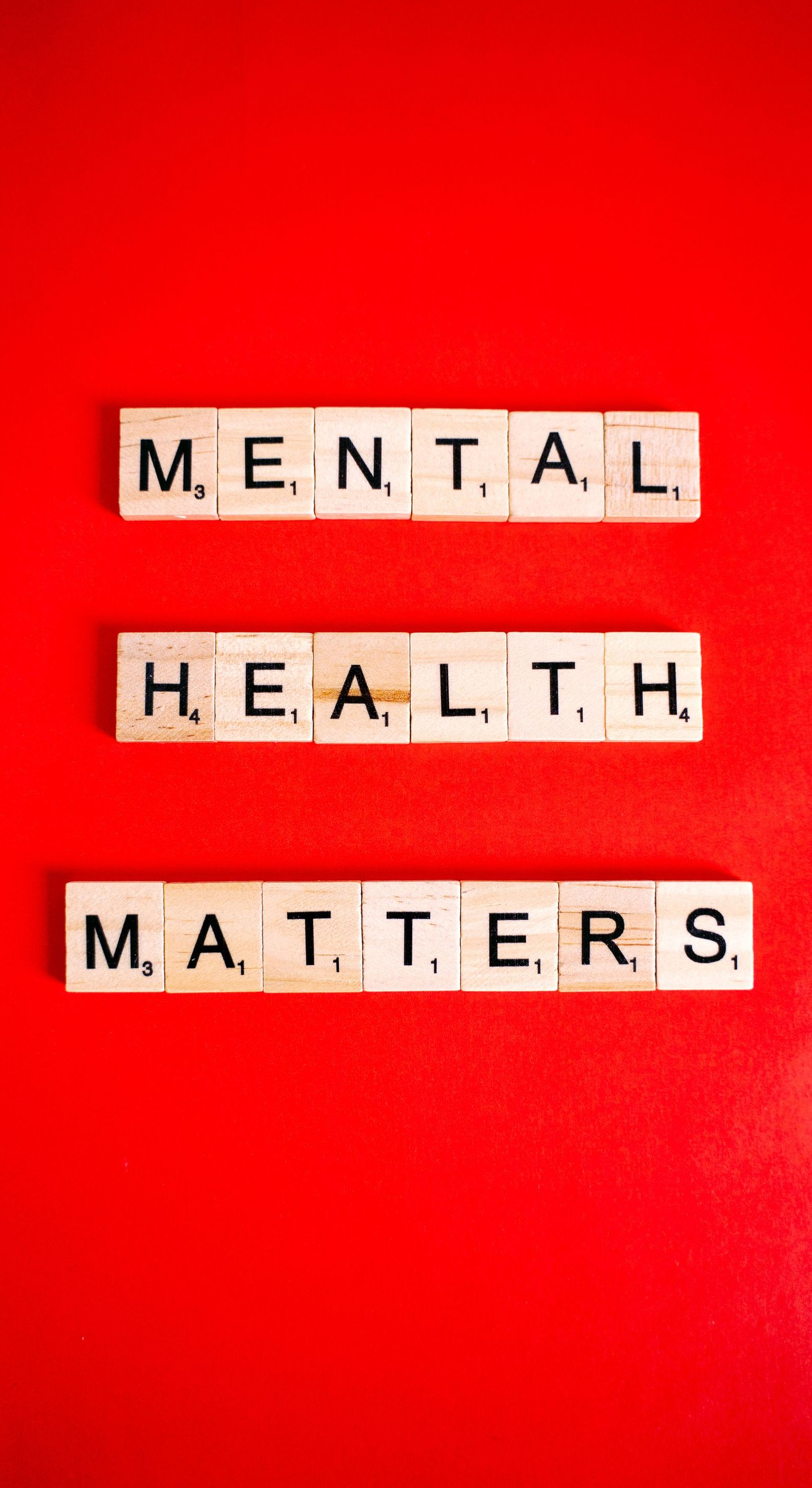 Scrabble tiles on red background spell “MENTAL HEALTH MATTERS.”