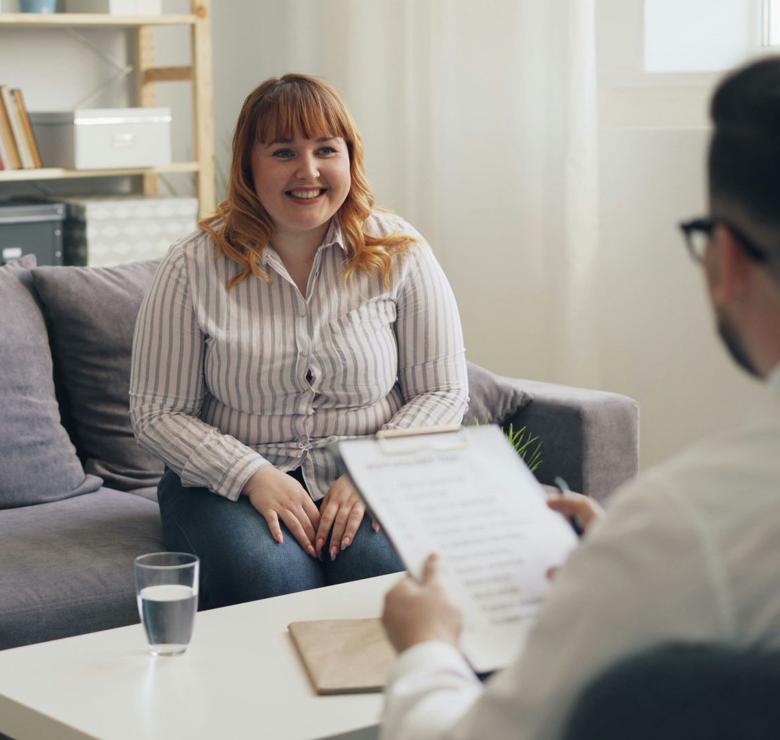 Woman smiling during a counseling session across from a clipboard in a bright office