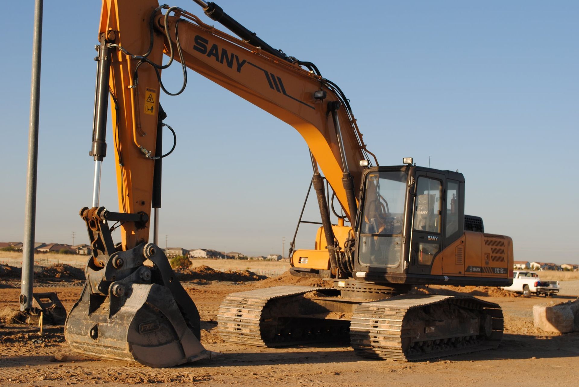 A yellow sany excavator is parked on a dirt road
