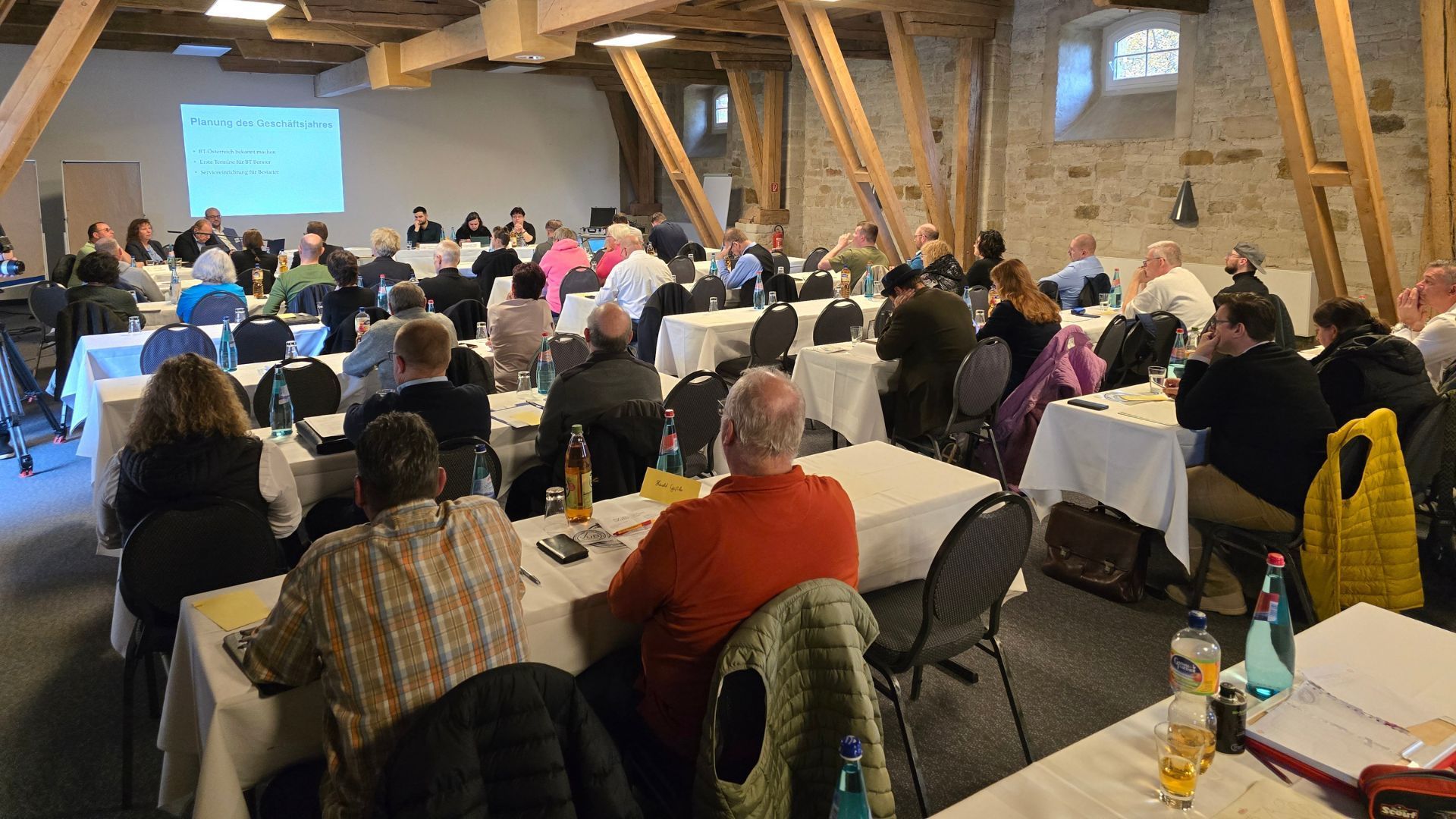 Eine Gruppe von Menschen sitzt bei einem Seminar des VuBs auf Stühlen in einem Raum.