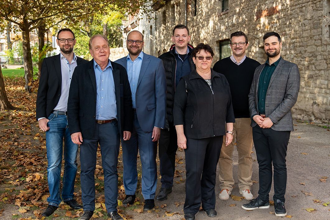 Eine Gruppe von Menschen, die nebeneinander auf einem Bürgersteig stehen