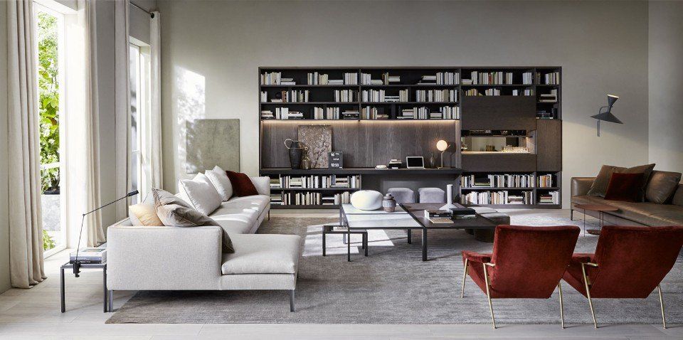 salotto con libreria nera e divano bianco angolare