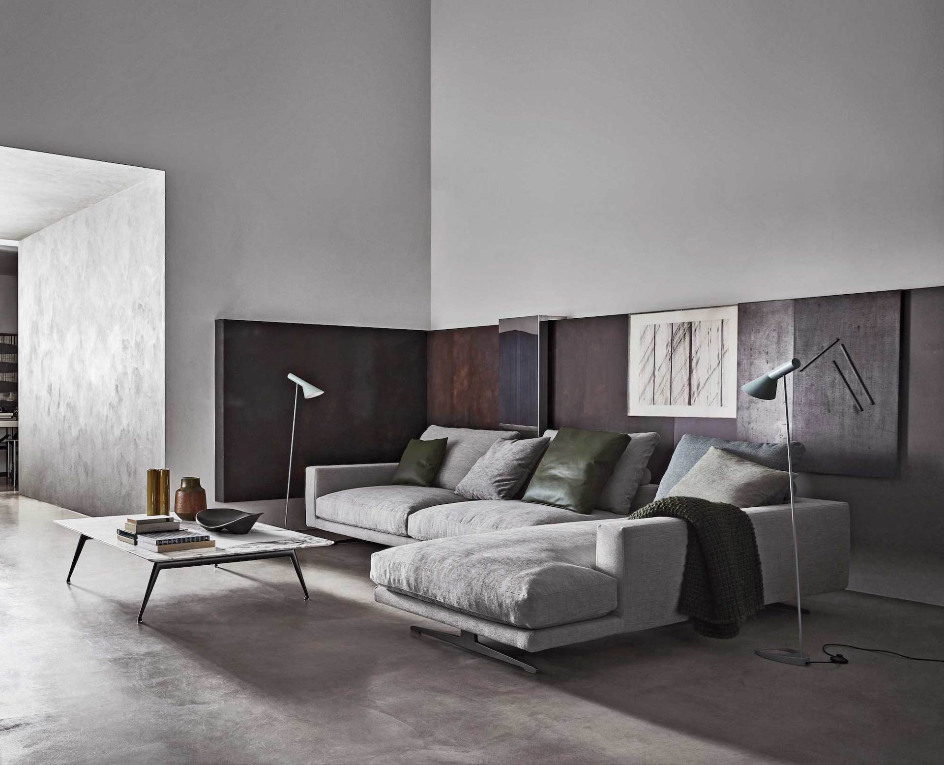 divano ad angolo grigio chiaro con cuscini verdi