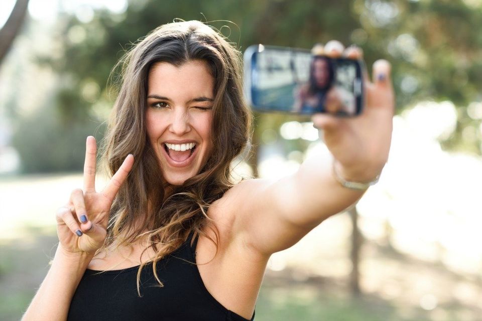 A Chapel Hill Dentist patient taking a selfie after whitening her teeth.