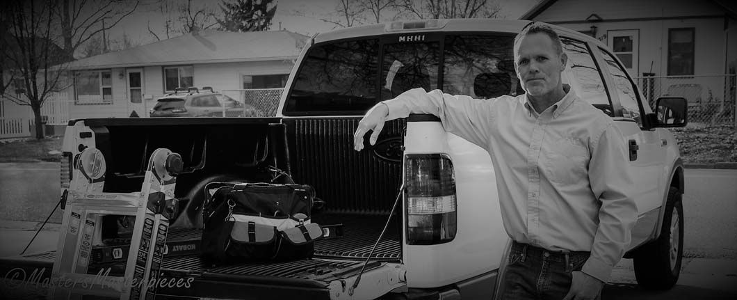 A man is standing next to the back of a truck.