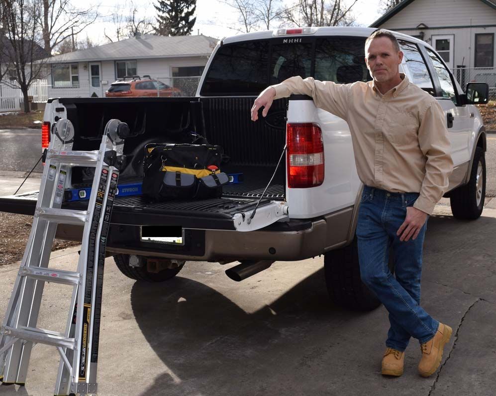 A man leaning against the back of a truck