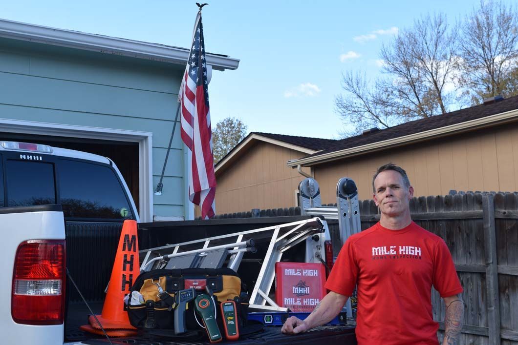 A man in a red shirt is standing in front of a truck