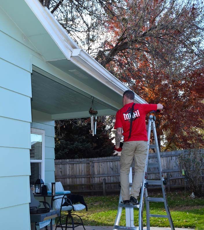 A man on a ladder with a red shirt that says miami