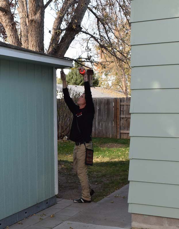 A man is working on a shed with a drill