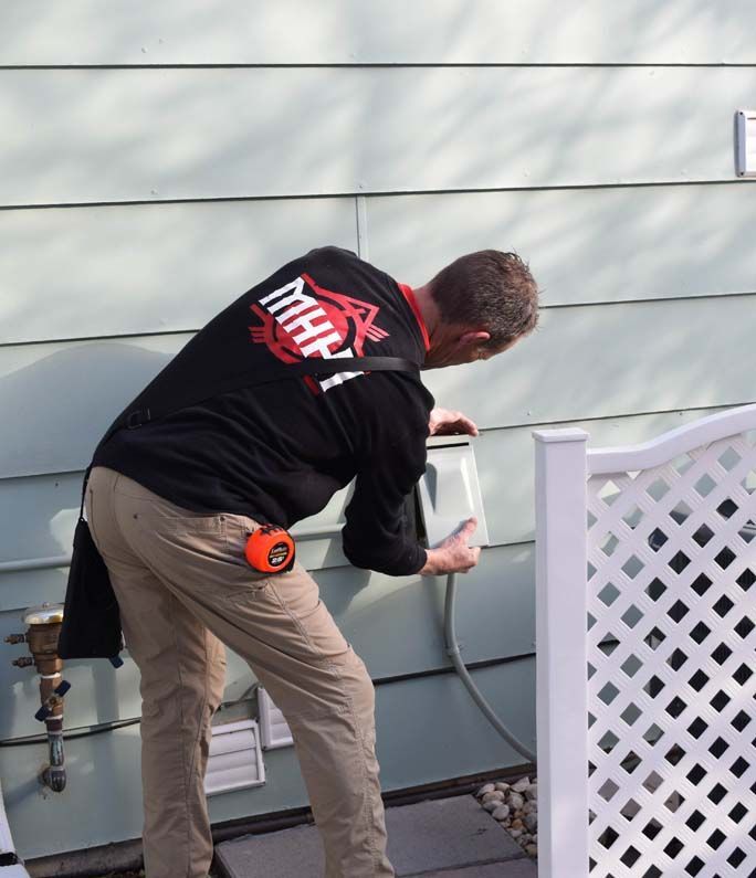 A man wearing a black shirt that says mhk on the back