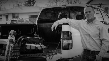 Jeff Durham standing next to the back of a truck.