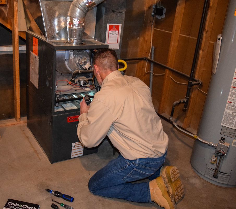 A man is working on an air conditioner in a basement