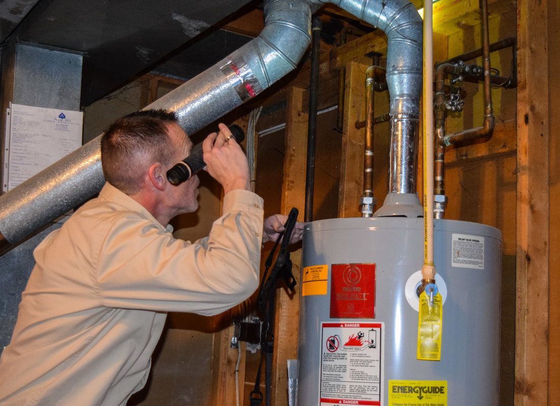 A man is looking through binoculars at a water heater.