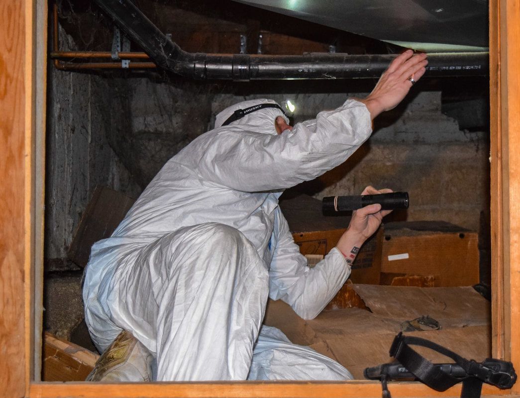 A man in a white suit is looking through a window