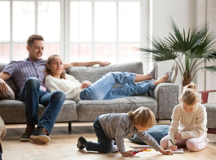 A family is sitting on a couch in a living room.