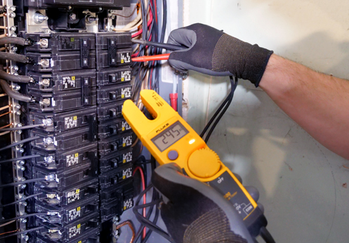 A man is working on a server with a screwdriver.