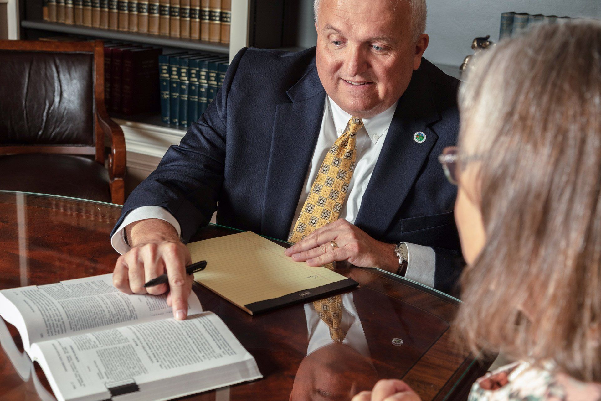 A man in a suit and tie is sitting at a table talking to a woman – Jonesborough, TN - Law Offices of James R Wheeler