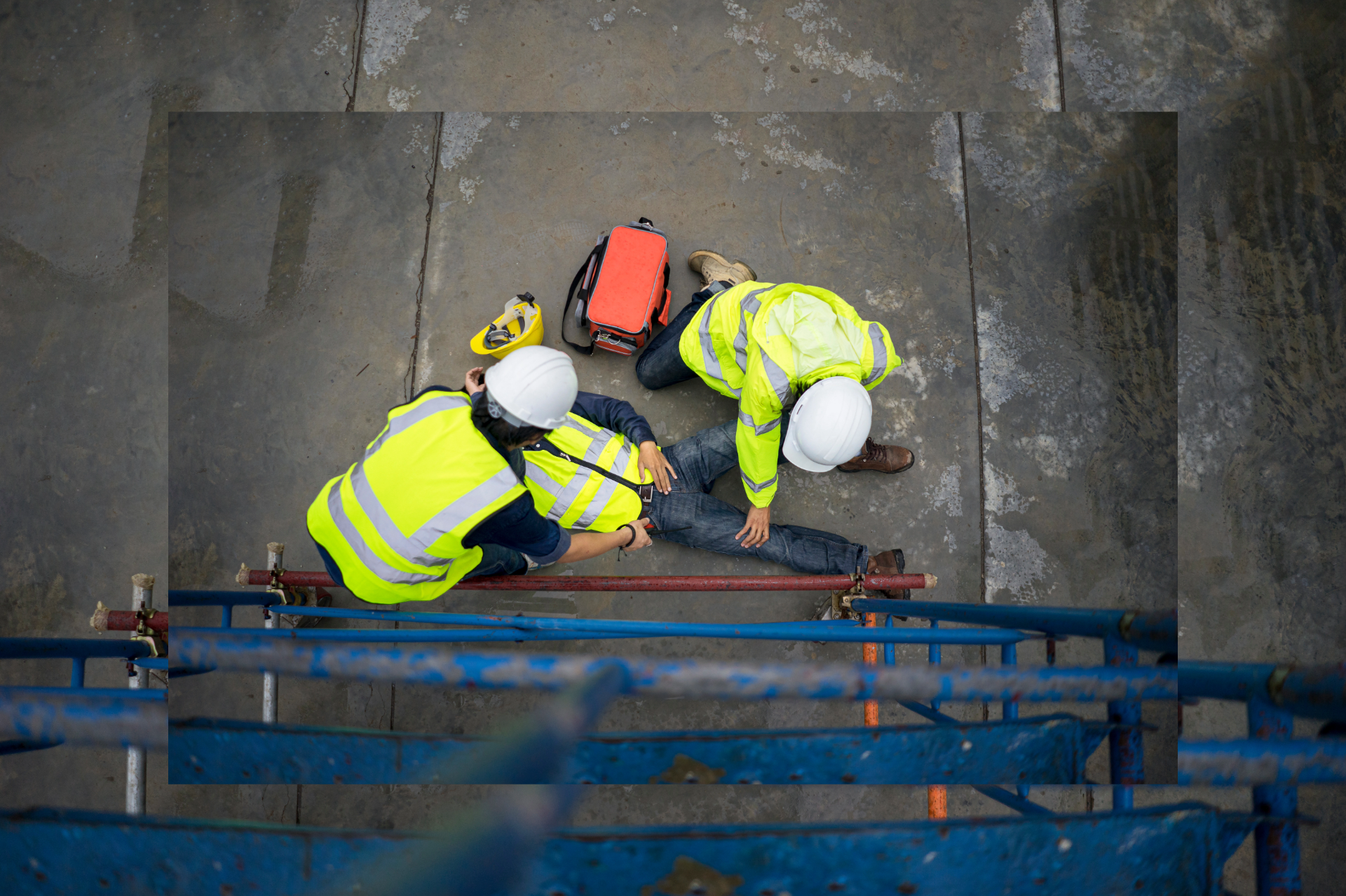 Construction workers helping a fallen colleague on a scaffold, high-angle view.