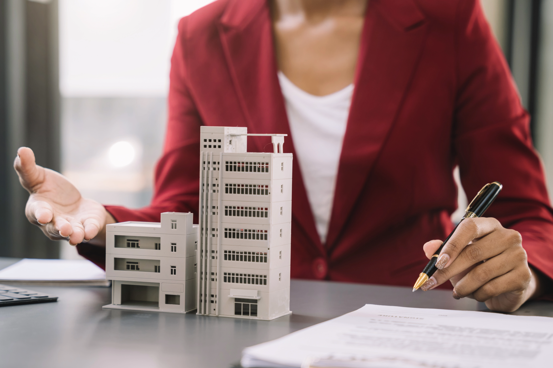 A group of people are sitting at a table with papers and a laptop.